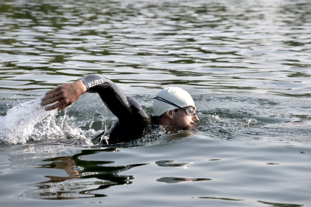 Male swimmer in wetsuit and goggles outdoors. Swimming crawl and freestyle. WendyAndrewsPhotography